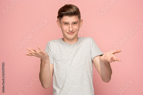 Suspiciont. Doubtful pensive man with thoughtful expression making choice against pink background
