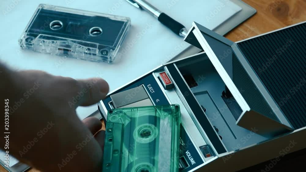 Stop and eject audio cassette from player, hand taking the tape