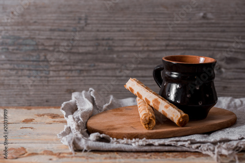 Tea with biscuits crackers on an old wooden board, on a crumpled linen napkin, on a vintage table, top view, wabi sabi series photo