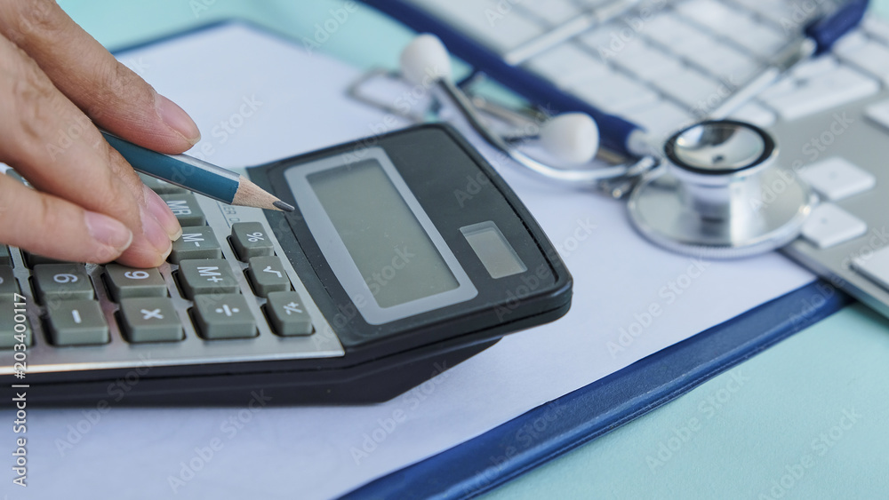 medical cost closeup calculates on an electronic calculator medical cost closeup calculates on an electronic calculator