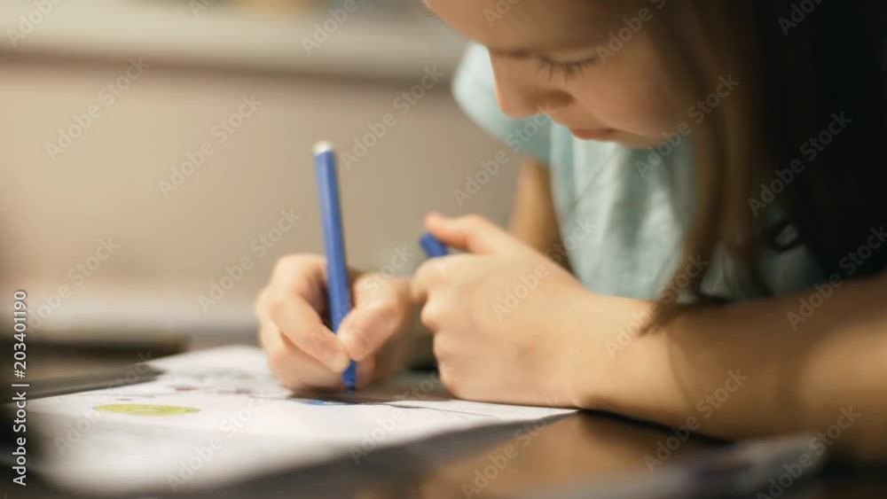 Little girl at the table draws a felt-tip pen. Little girl at the table draws a felt-tip pen.