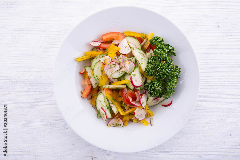 The spring vegetable fresh vegetables salad seasoned with sunflower oil with greens The spring vegetable fresh vegetables salad seasoned with sunflower oil with greens