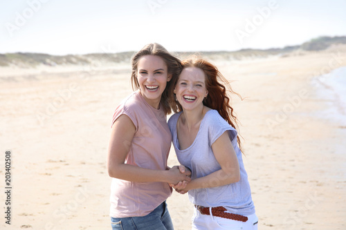 Zwei hübsche Frauen an einem Strand lachen © Joerch