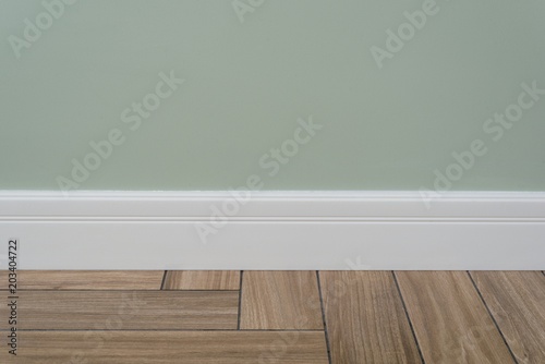 Light green matte wall, white baseboard photo