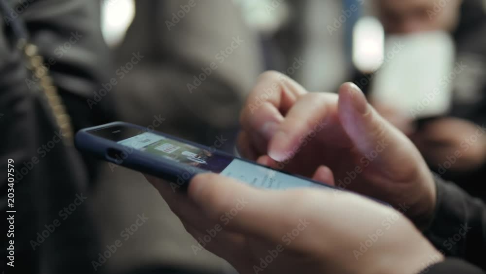 Young handsome businessman with smartphone in subway, man student use phone in train transportation with people peak rush hour Young handsome businessman with smartphone in subway, man student use phone in train transportation with people peak rush hour