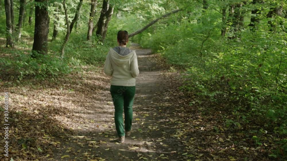 lonely woman walking alone into the woods lonely woman walking alone into the woods