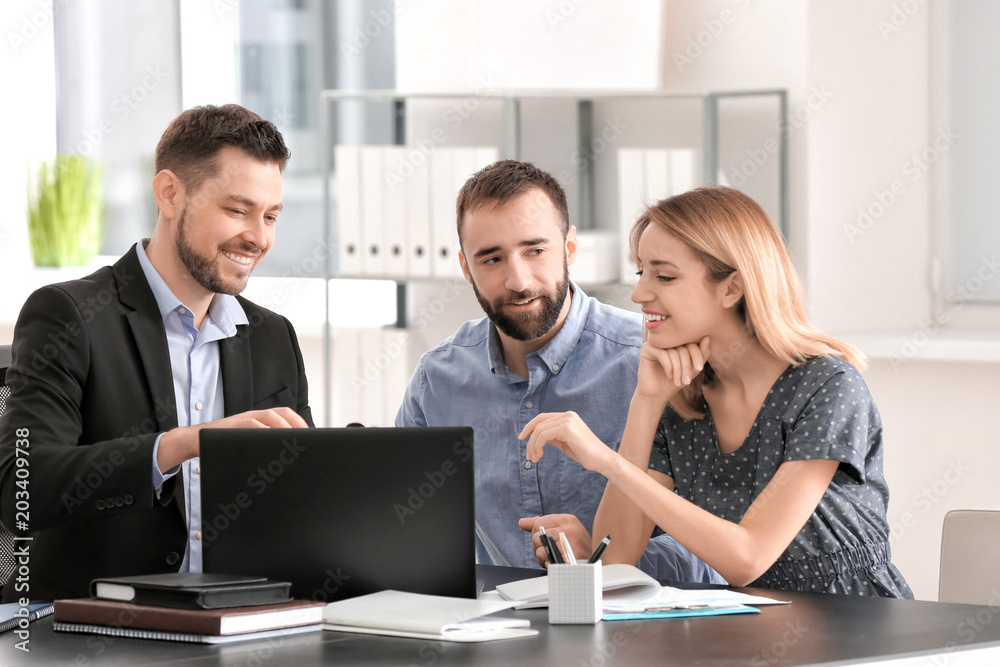 Businessman consulting young couple in office Businessman consulting young couple in office