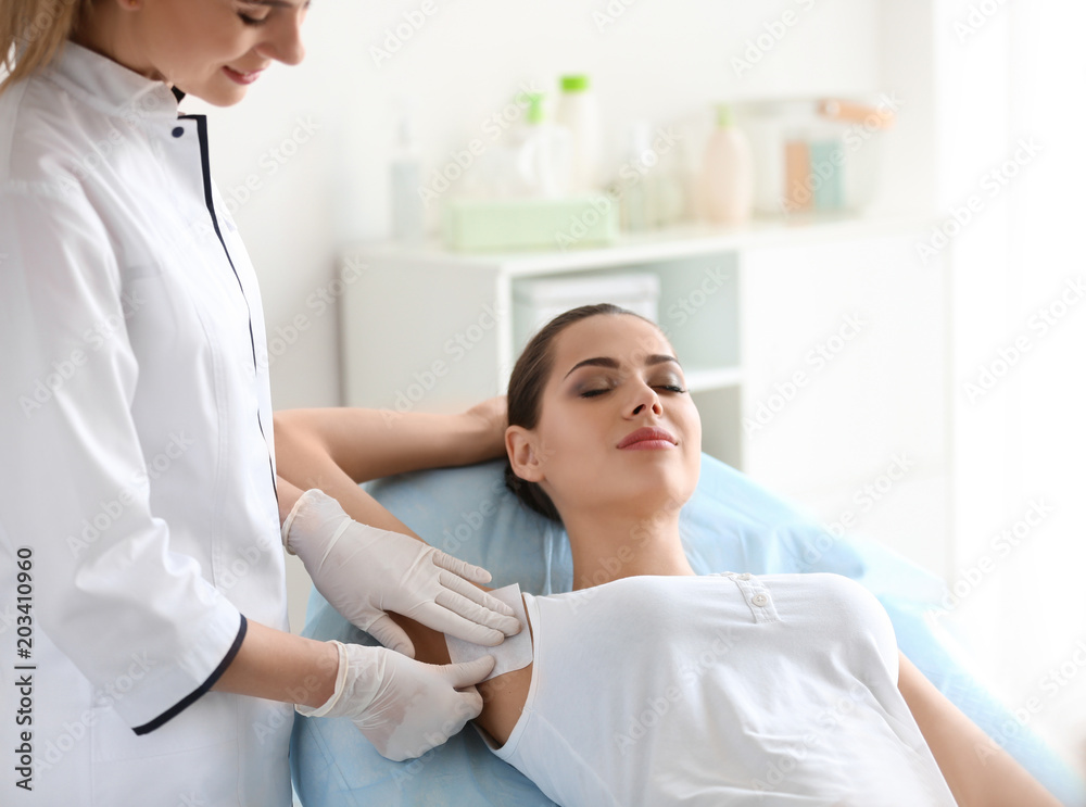 Woman getting wax epilation in salon Woman getting wax epilation in salon