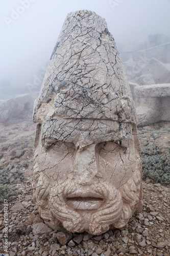 Ruined ancient stone statue of Heracles on the top of Nemrut mount, Anatolia, Turkey photo