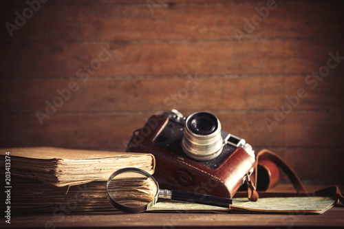 little magnifier and book with camera on a table. Image in old color style
