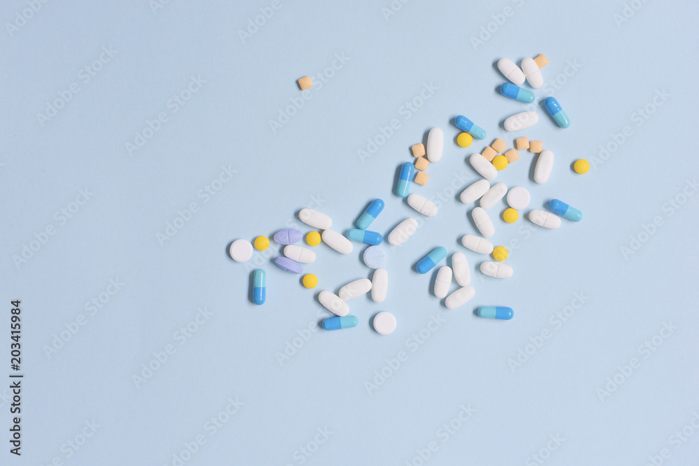 Healthcare and medical series - medicine pills, tablets and capsules on blue background