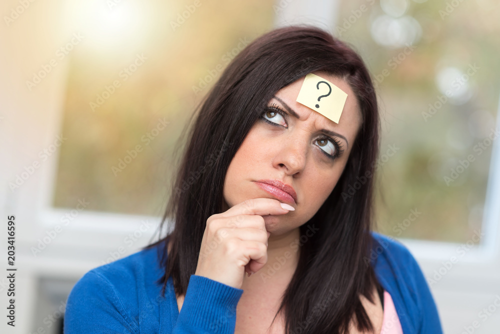 Young woman with question mark on her forehead Young woman with question mark on her forehead