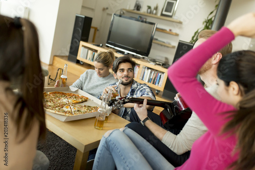 Young people having pizza party in the room