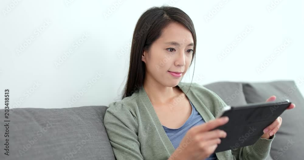 Woman watching on tablet computer at home Woman watching on tablet computer at home