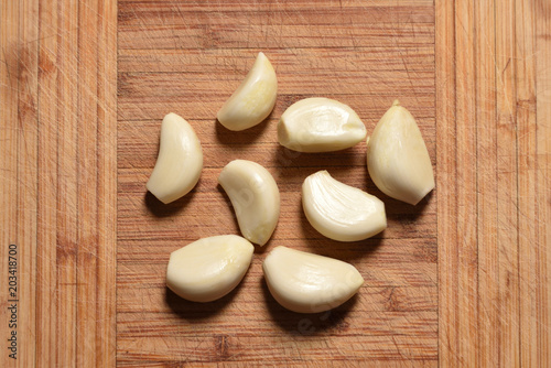 Fresh and peeled garlic is on the cutting board. close-up