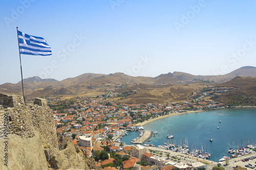 Beautiful panorama view on greek harbor city Myrina on small island Limnos in Aegean sea in Greece with wawing flag. Touristic place.