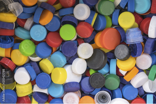Close up view on colorful plastic bottle caps prepared for recycling. Enviromental and ecological catastrophe, plast is everywhere.