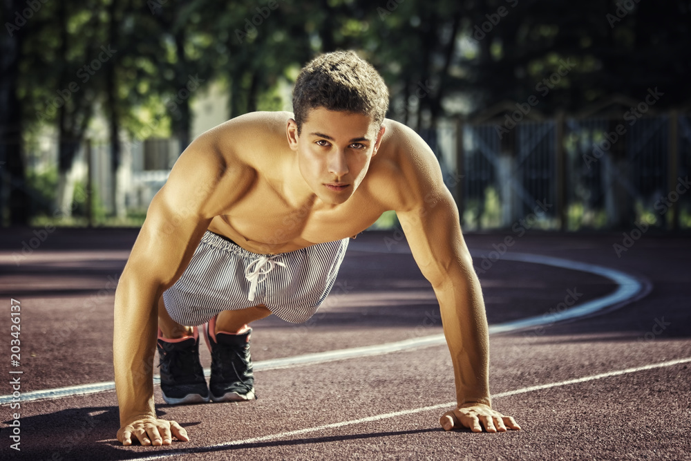 Obraz premium Attractive fitness man doing exercises in park