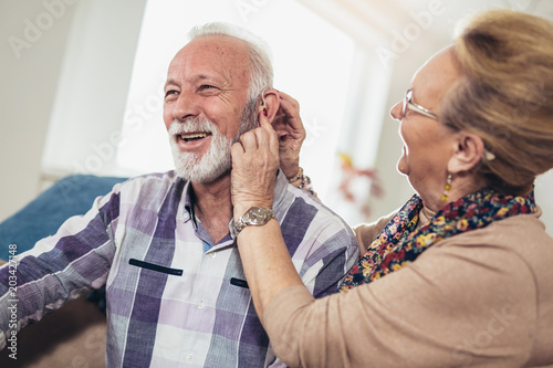Older man and woman or pensioners with a hearing problem photo
