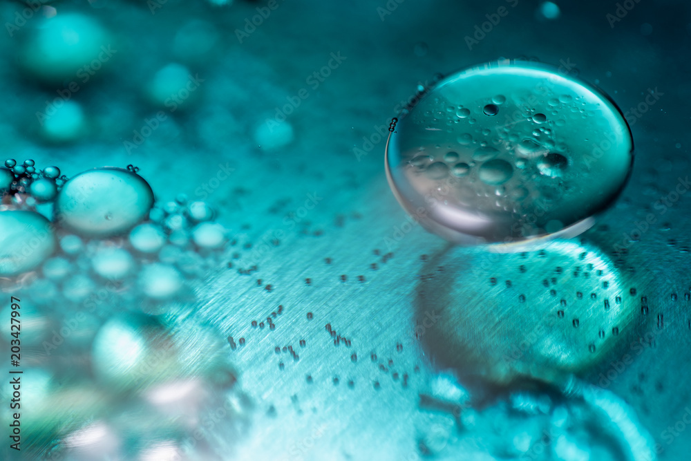 Colored oil drops and bubbles on a metal gear engine surface. Closeup photo. Colored oil drops and bubbles on a metal gear engine surface. Closeup photo.