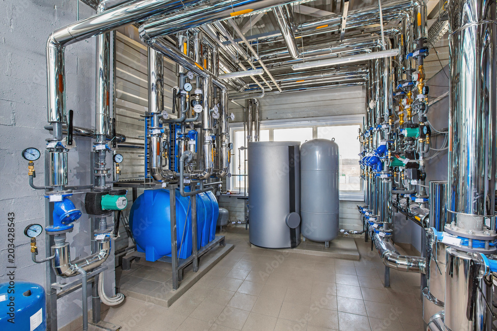 The interior of an industrial boiler house with a multitude of pipes, barrels and sensors The interior of an industrial boiler house with a multitude of pipes, barrels and sensors