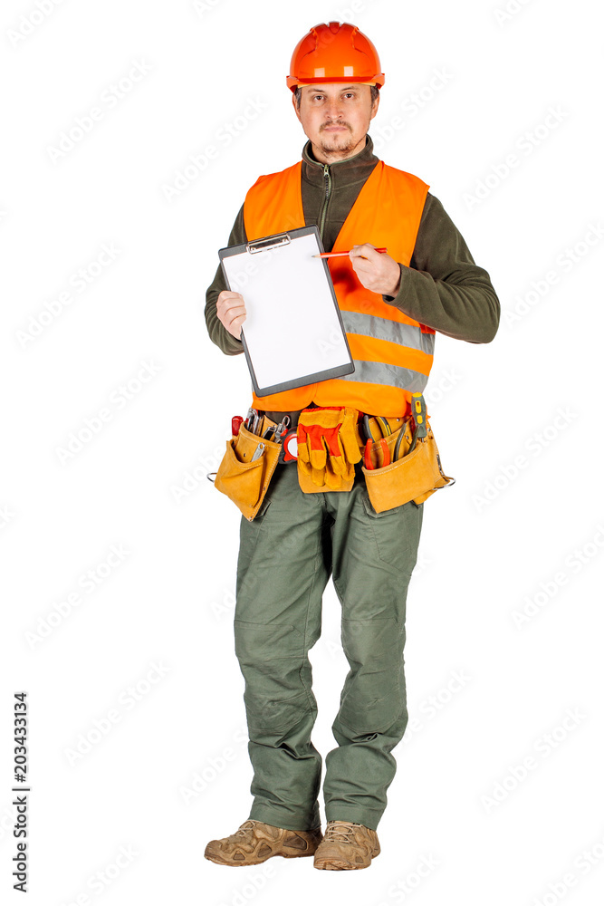 male builder or manual worker in helmet holding a clipboard and pointing with a pen over white wall background.