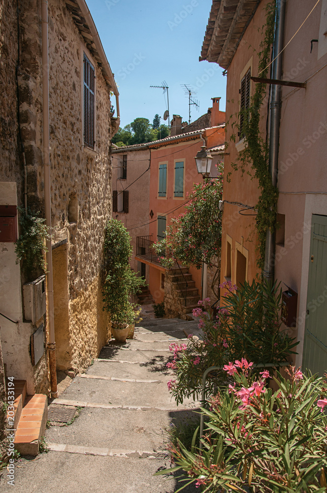 View of stone houses in alley on the slope under blue sky, at the gorgeous medieval hamlet of Les Arcs-sur-Argens, near Draguignan. Located in the Provence region, Var department, southeastern France