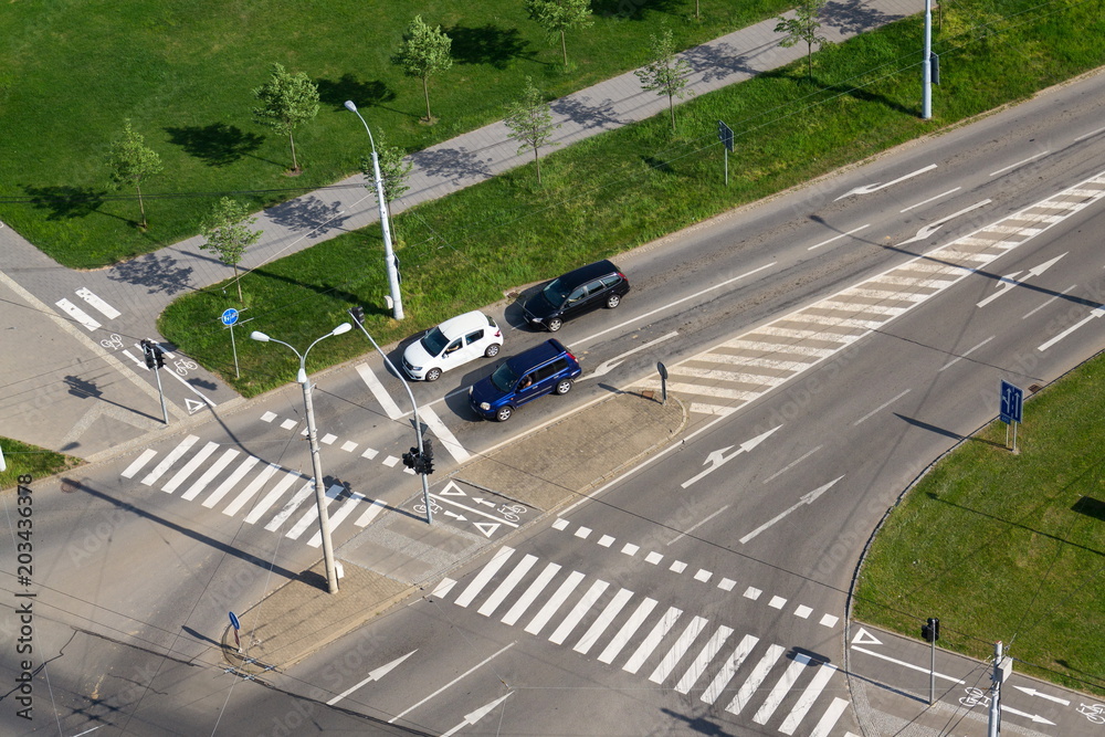 Cars standing in front of crosswalk on crossroad, aerial view