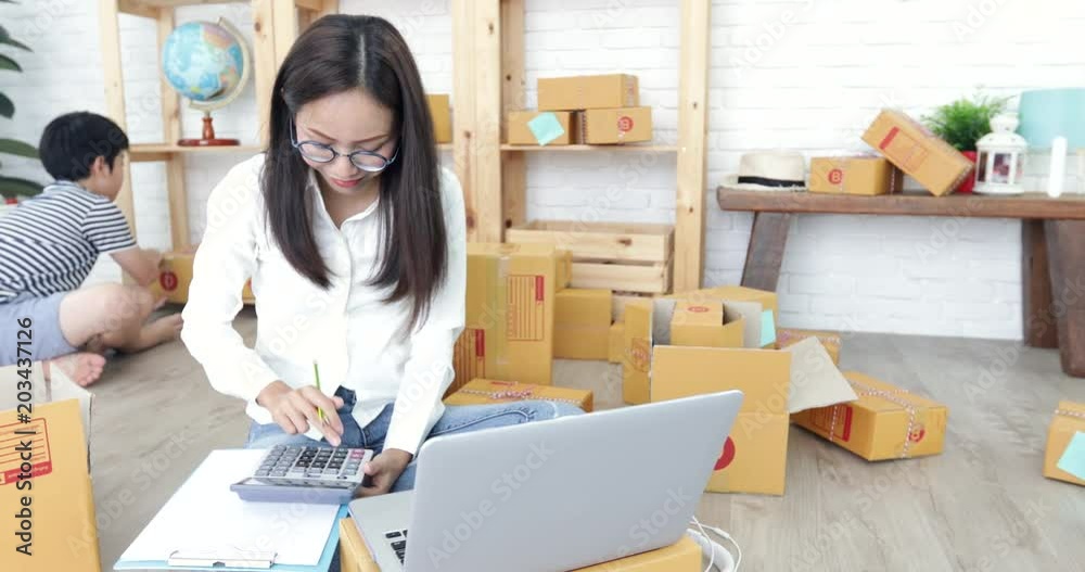 Young asian woman with child boy working and packing Thailand post box to send ,Young business start up. SME, Delivery Project, Young asian woman with child boy working and packing Thailand post box to send ,Young business start up. SME, Delivery Project,