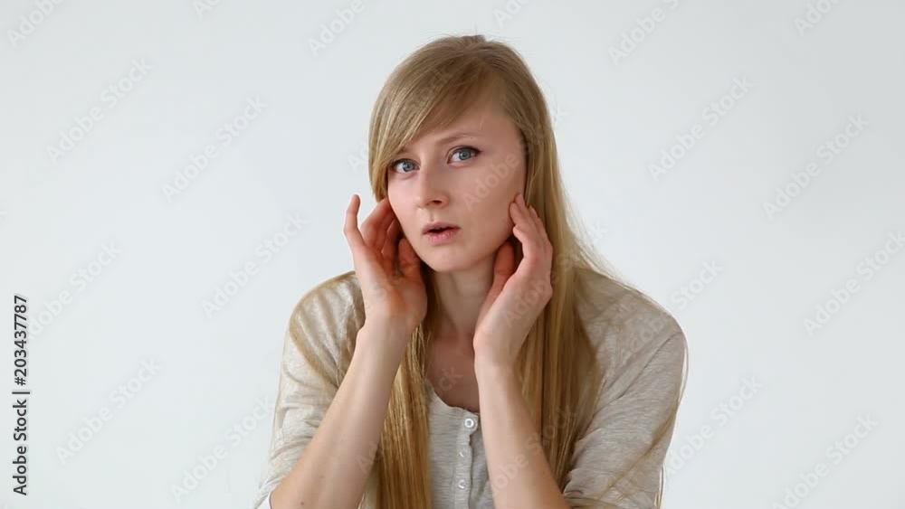beautiful long-haired girl of European appearance with blond hair looks at her face closeup beautiful long-haired girl of European appearance with blond hair looks at her face closeup