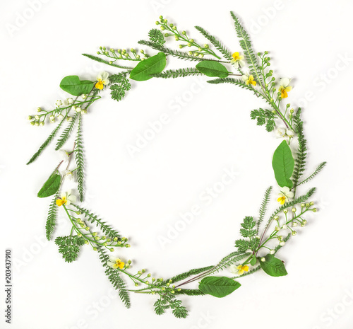 Round frame wreath made of spring flowers and leaves isolated on white background. Flat lay. Top view.