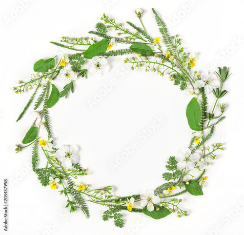 Fototapeta Naklejka Na Ścianę i Meble -  Round frame wreath made of spring flowers and leaves isolated on white background. Flat lay. Top view.