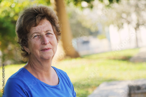 close up portrait of senior woman sitting in outdoor summer cafe