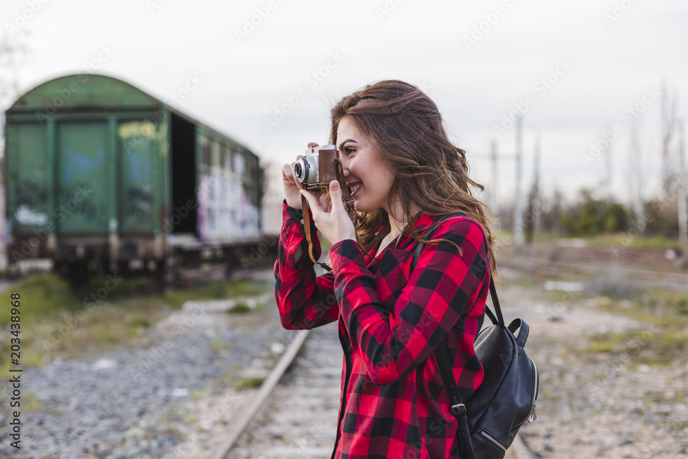 young beautiful woman wearing casual clothes taking a picture with a vintage camera. Outdoors city background. Lifestyle. young beautiful woman wearing casual clothes taking a picture with a vintage camera. Outdoors city background. Lifestyle.