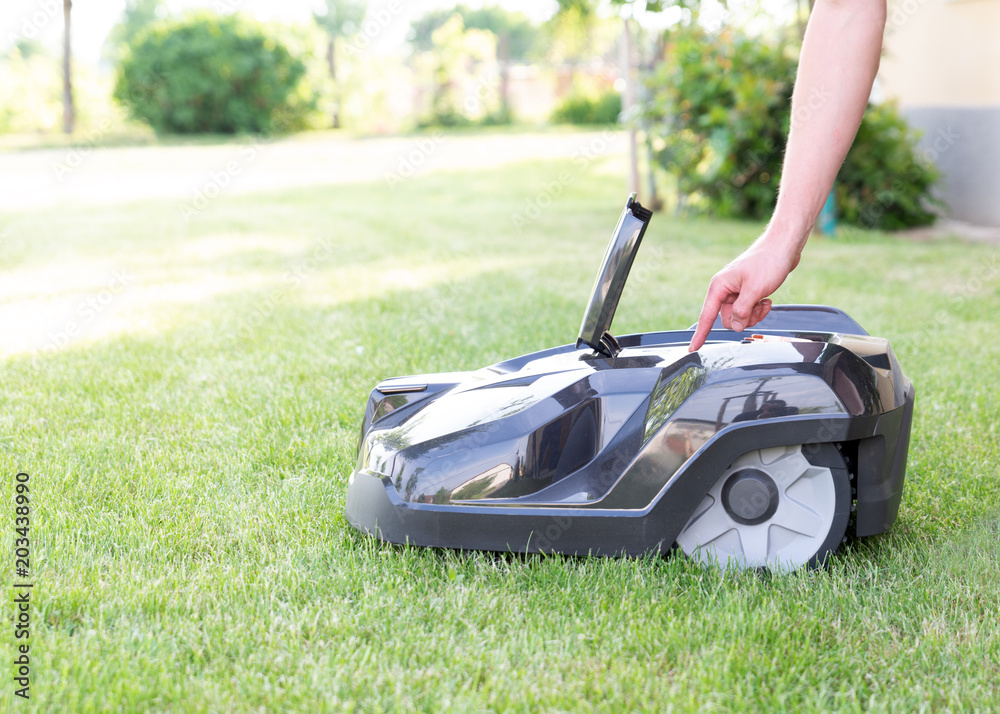 Rasen Roboter, Mähroboter mit Hand beim Einschalten, Hintergrund, Zukunft