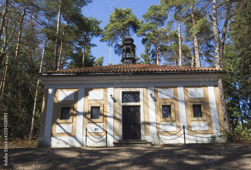 small chapel in baroque monastery Skalka on  sunny day early spring, green pine tree and blue sky background photo