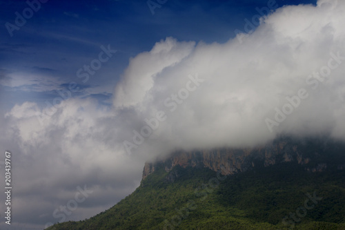 Landscape of big mountain with white cloudy on top under blue sky at Chong Sadao Kanchanaburi Province of Thailand.