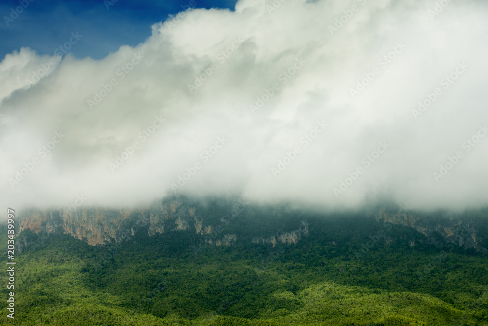 Landscape of big mountain with white cloudy on top under blue sky at Chong Sadao Kanchanaburi Province of Thailand.