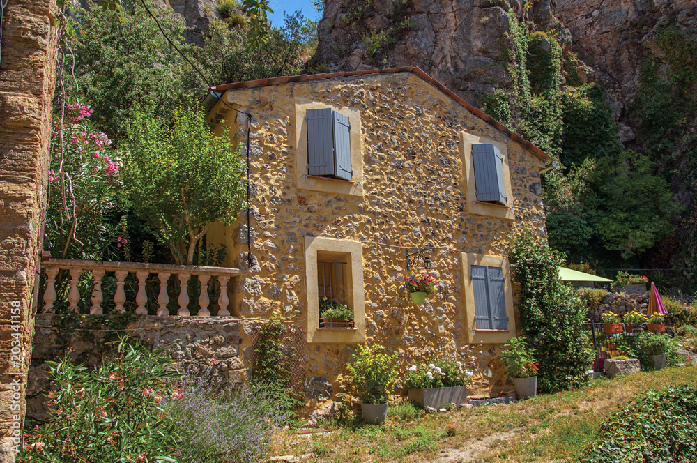 Alley view with house and flowers in Chateaudouble, a quiet and tourist village with medieval origin on a sunny summer day. Located in the Var department, Provence region, southeastern France
