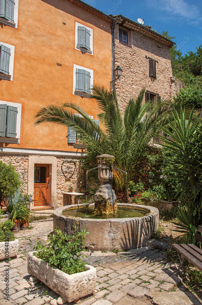 View of house facing a square with fountain in Chateaudouble, a quiet and tourist village with medieval origin on a sunny day. Located in the Var department, Provence region, southeastern France