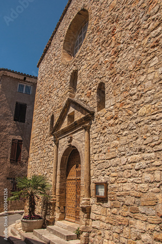 Stone made facade of ancient church in Chateaudouble, a quiet and tourist village with medieval origin on a sunny summer day. Located in the Var department, Provence region, southeastern France photo