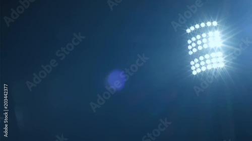 Background of football/soccer/sports stadium lights agains dark sky, net in front, 4k
