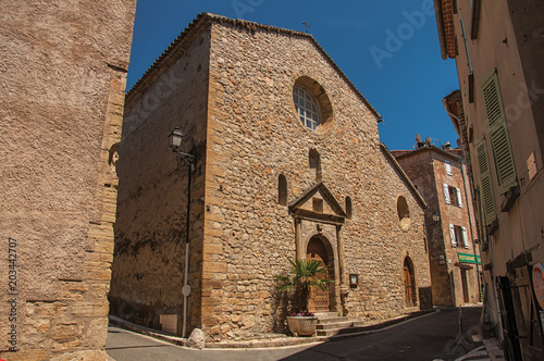 Stone made facade of ancient church in Chateaudouble, a quiet and tourist village with medieval origin on a sunny summer day. Located in the Var department, Provence region, southeastern France photo