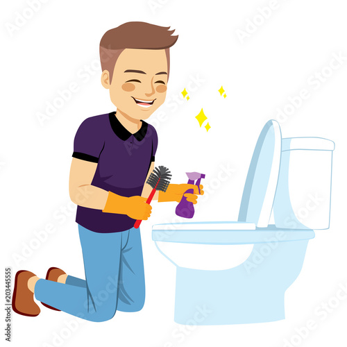 Young happy man on his knees cleaning bathroom toilet