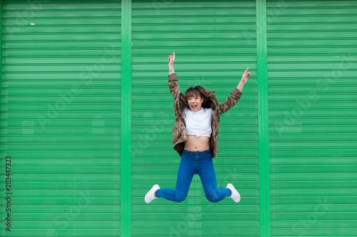 Young asian woman jumping high in happiness