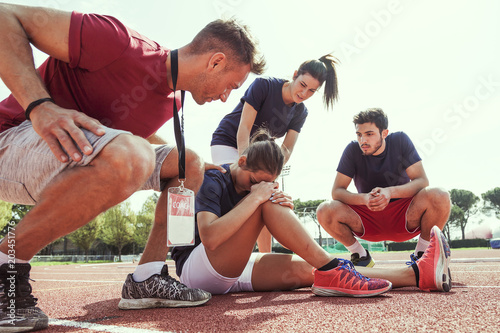 Fotografia young athlete injured to knee on the track