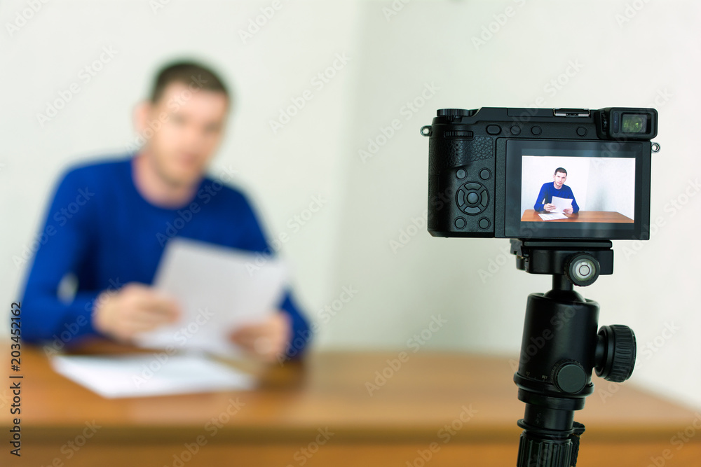 Young man recording video using a tripod mounted digital camera. fake news  concept Stock Photo | Adobe Stock