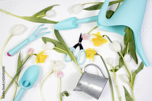 Fototapeta Naklejka Na Ścianę i Meble -  the Yellow rubber boots with a bouquet of flowers of yellow daffodils and white and pink tulips. Garden accessories.