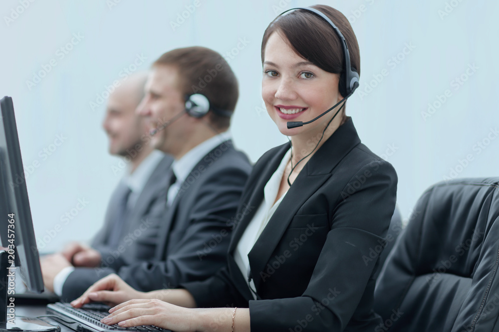 Beautiful business people in headsets are using computers Beautiful business people in headsets are using computers