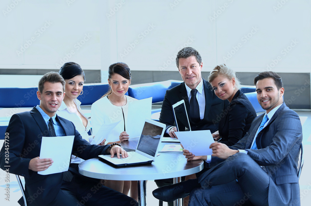 group of business people with documents sitting at a table in the lobby of the Bank. group of business people with documents sitting at a table in the lobby of the Bank.